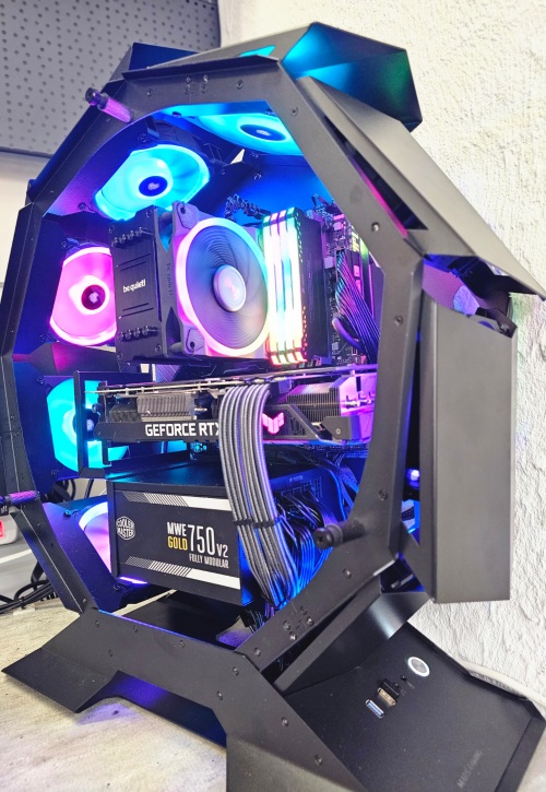 Intérieur d'un PC assemblé sur mesure : carte graphique, alimentation 750 W et câbles passés derrière la plaque, boîtier ouvert.