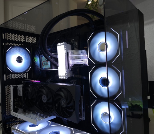 PC sur mesure monté par AdrianPCMaster à Sierre : vitre latérale, watercooling AIO et ventilateurs à éclairage blanc, carte graphique visible.